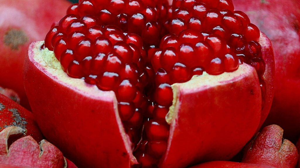 Vibrant Red Pomegranate Wallpaper: Juicy Seeds & Rich Color Background
