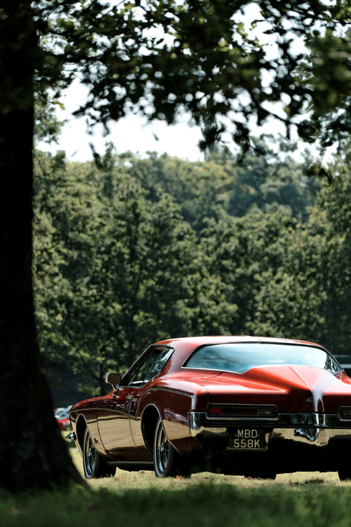Nostalgic Red Retro Car in Lush Green Forest Background Wallpaper