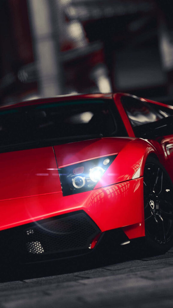 Red sports car speeding with glowing headlights sleek design dynamic motion modern elegance wallpaper