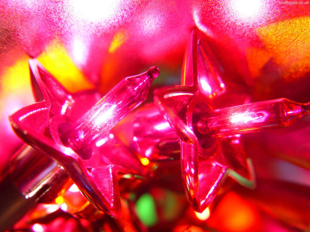 Close-up of vibrant glowing red star-shaped lights festive colorful wallpaper background