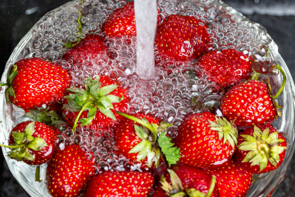 Vibrant Red Strawberries in Water: Refreshing Wallpaper Background
