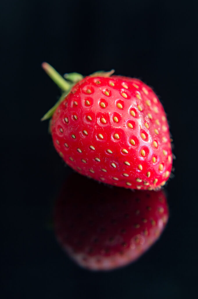 Glossy Red Strawberry Macro Shot on Black | Vibrant Wallpaper Background