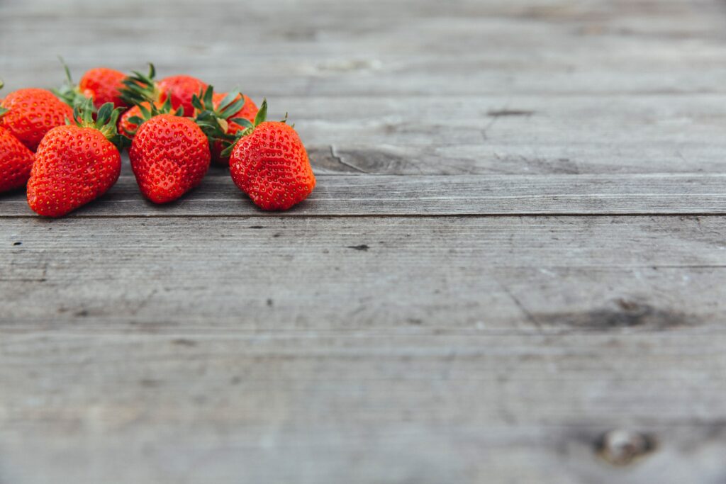 Vibrant Red Strawberry Wallpaper on Rustic Wood Background