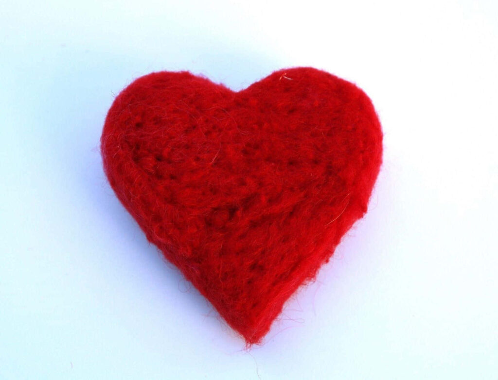 Vibrant Red Fabric Heart on White Background - Love & Warmth Wallpaper