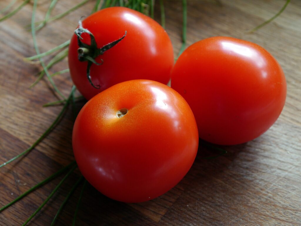 Vibrant Red Tomatoes with Green Garnish – Rustic Wallpaper Background