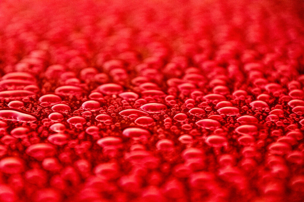 Vibrant Red Surface with Macro Water Droplets - Stunning Wallpaper