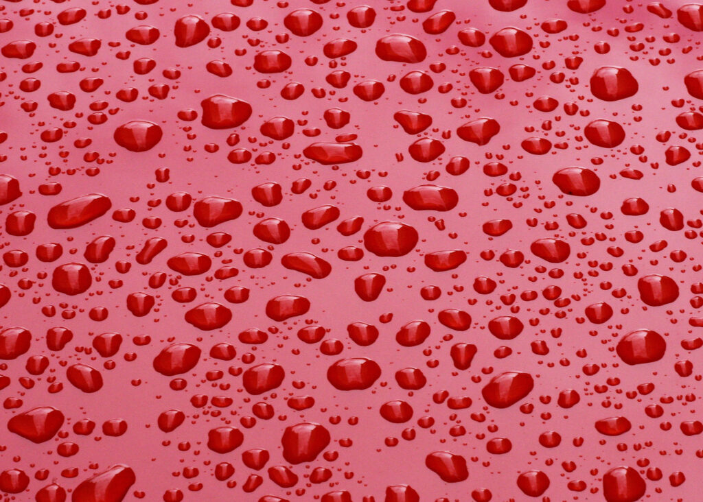 Vibrant Red Wallpaper with Water Droplets: Refreshing Background Art