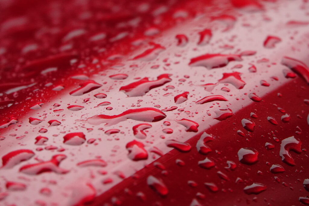 Vibrant Red Wallpaper: Macro Water Droplets on Glossy Surface