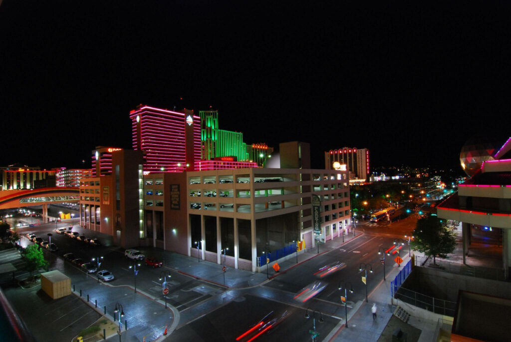 Vibrant Reno Nighttime Cityscape: Neon Lights Wallpaper Background