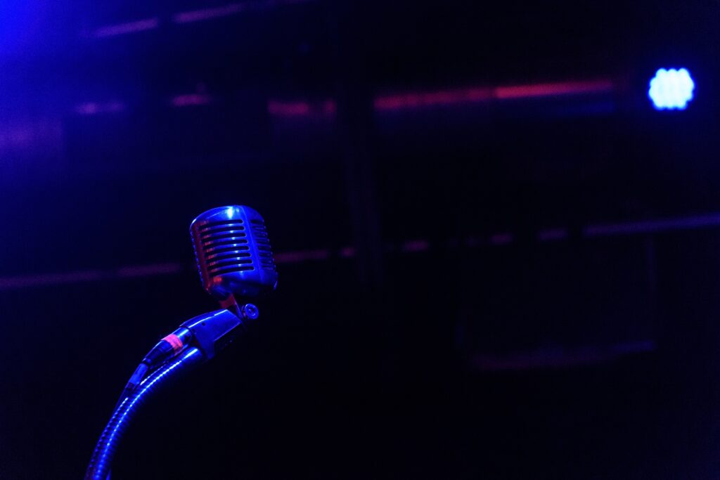 Vibrant Retro Microphone in Blue & Purple Stage Lighting Wallpaper