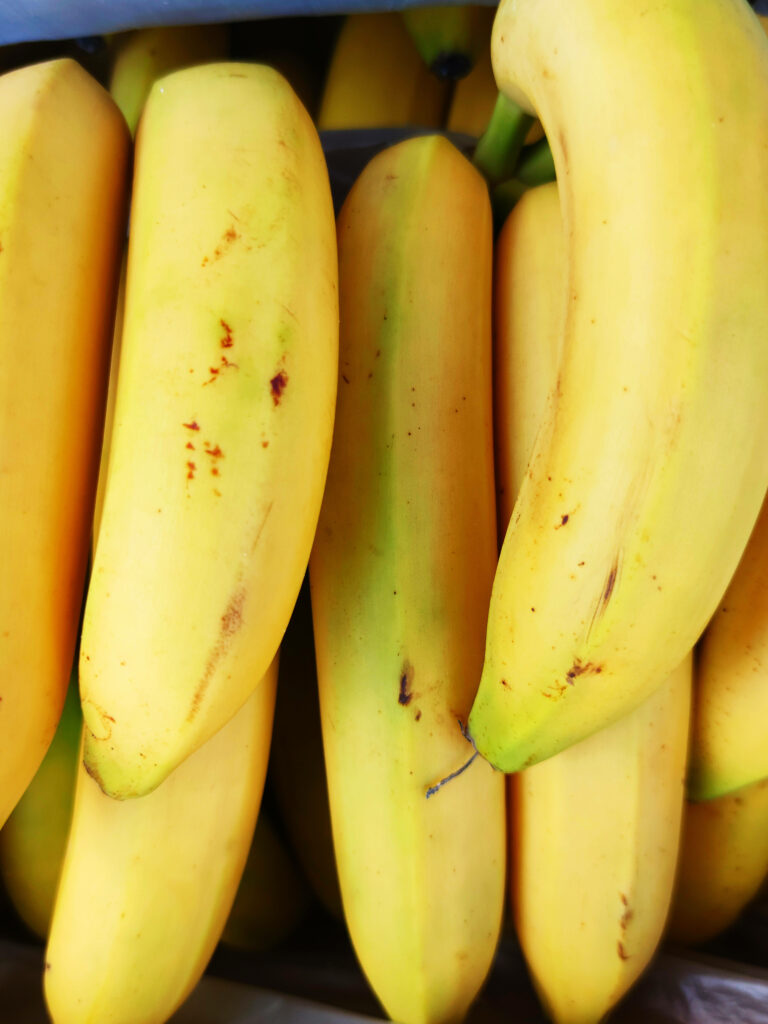 Close-up of ripe yellow bananas with smooth texture vibrant tropical fruit wallpaper background