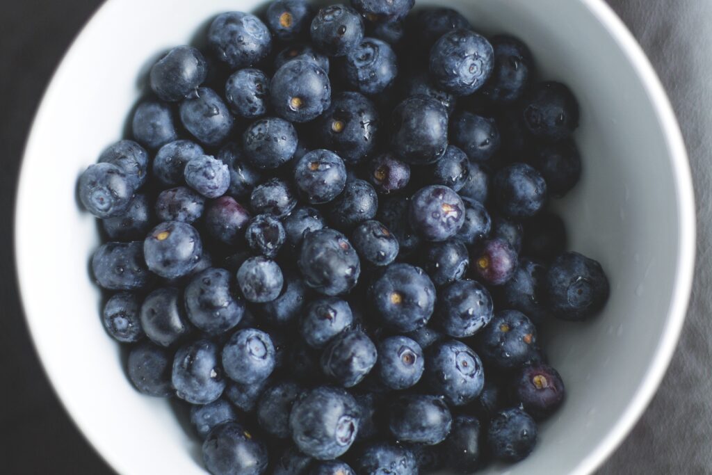 Vibrant Fresh Blueberries on White Plate - Wallpaper Background