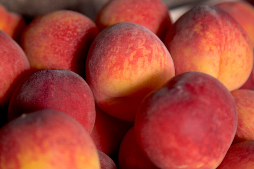 Vibrant Ripe Peaches Wallpaper: Macro Red & Gold Cluster Background