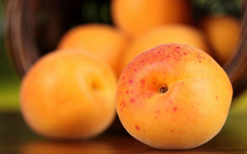 Vibrant Fresh Ripe Peaches in Woven Basket - Wallpaper Background