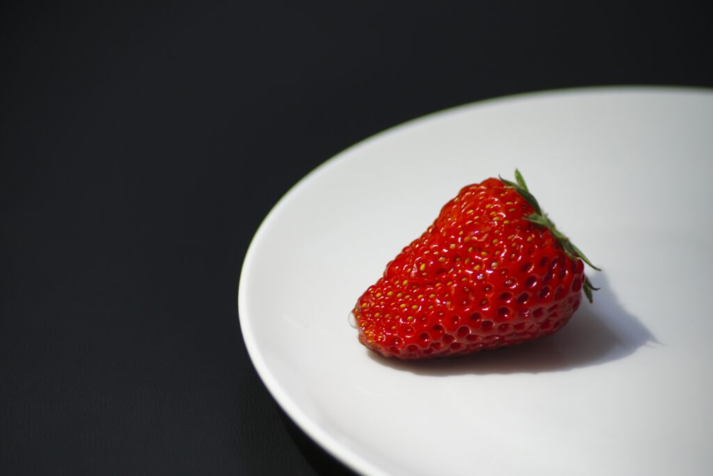Vibrant Ripe Strawberry on White Plate - Dark Wallpaper Background