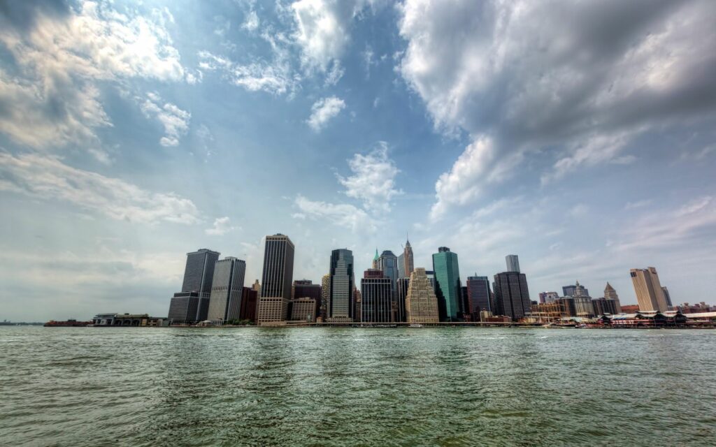 Vibrant Riverside Cityscape Wallpaper: Skyscrapers & Calm River Reflection