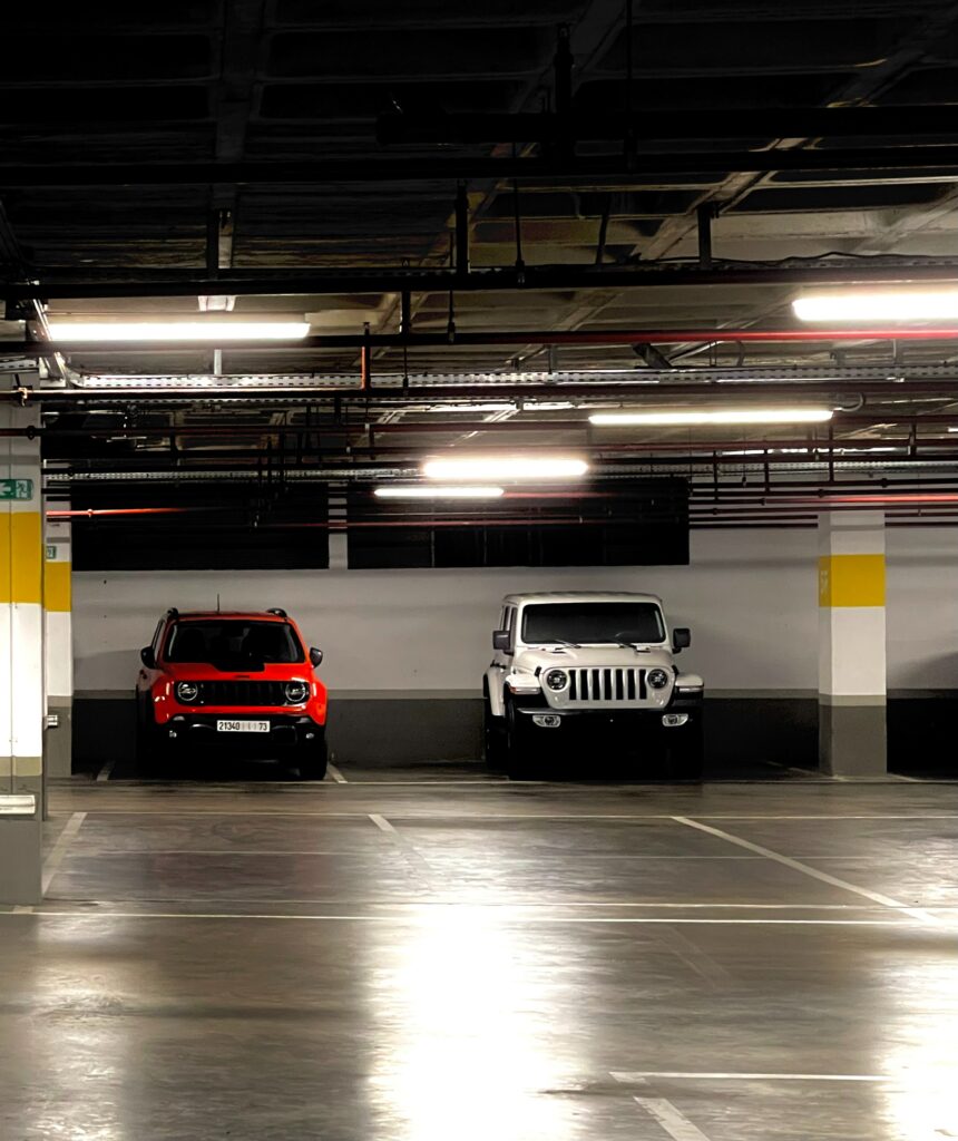 Vibrant SUVs in Dimly Lit Underground Parking Lot - Dramatic Contrast Wallpaper