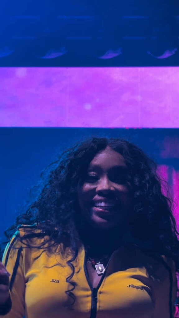 Vibrant SZA Concert Wallpaper: Energetic Stage Performance in Purple