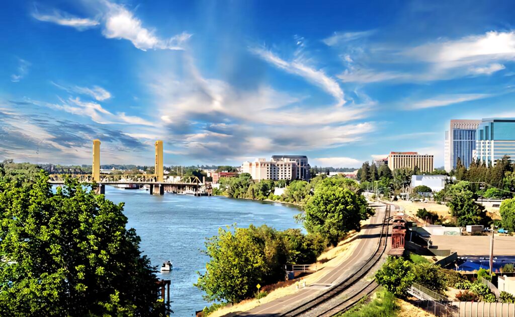 Vibrant Sacramento Cityscape: Tower Bridge & Lush River Wallpaper