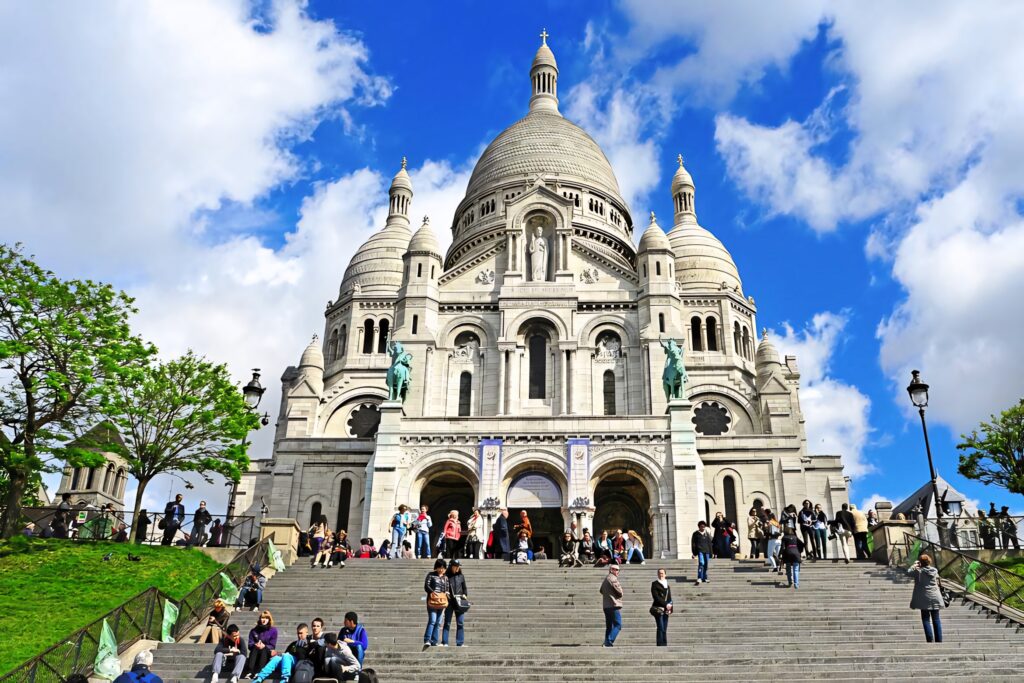 Vibrant Sacre Coeur Basilica View: Visitors & Lush Greenery Wallpaper