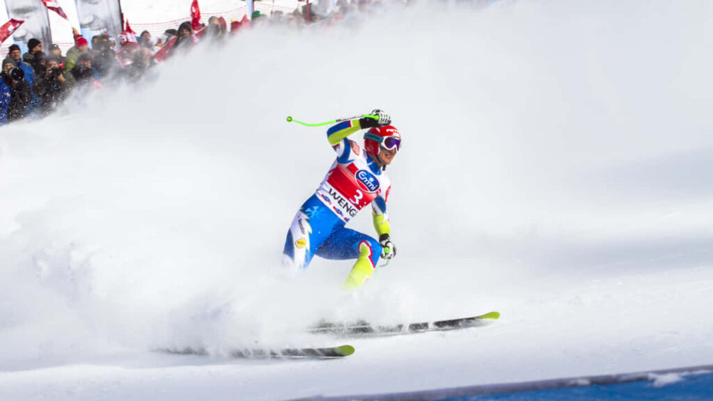 Vibrant Ice Skiing Wallpaper: Skier in Action with Snowy Background