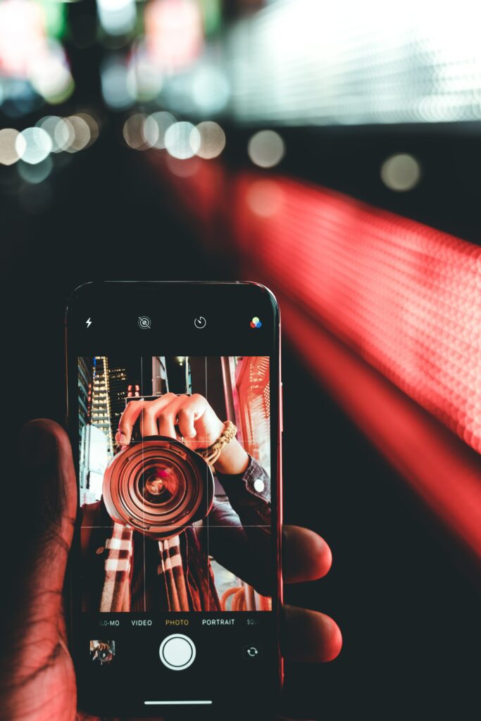 Vibrant Bokeh Wallpaper: Hand Holding Smartphone with Photography App