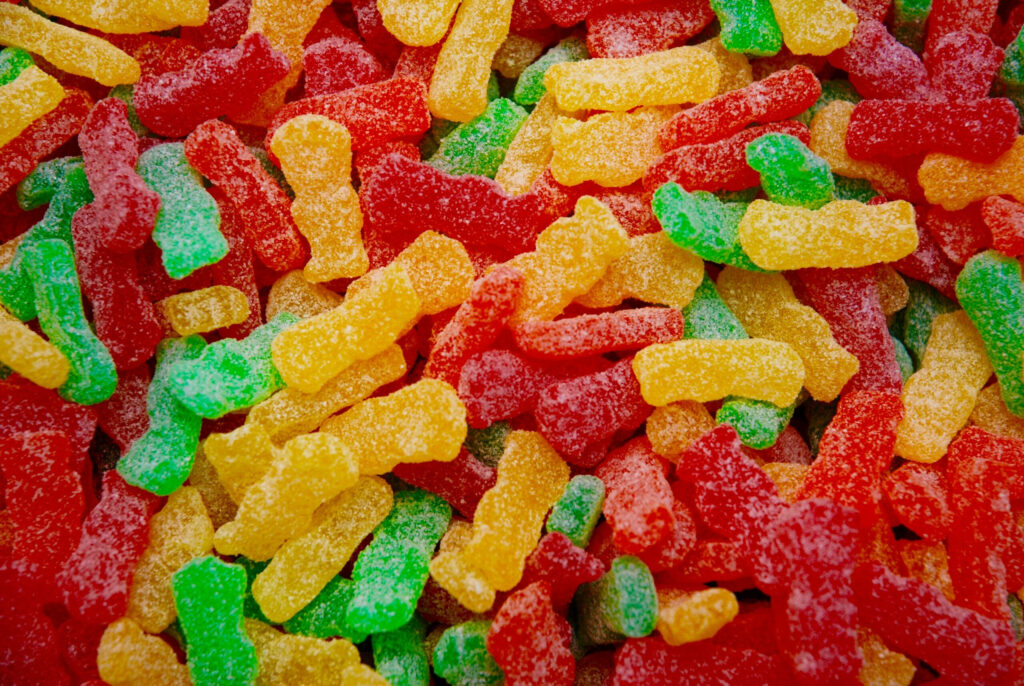 Vibrant Sour Gummy Worm Wallpaper: Colorful Candy Background