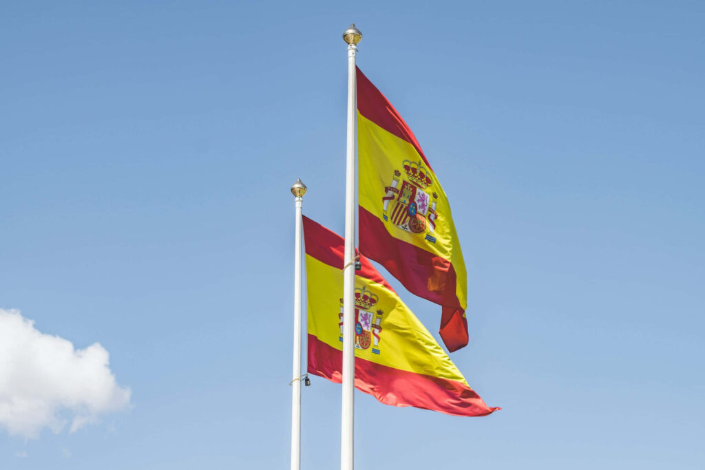 Vibrant Spanish Flags Wallpaper Against Clear Blue Sky Background