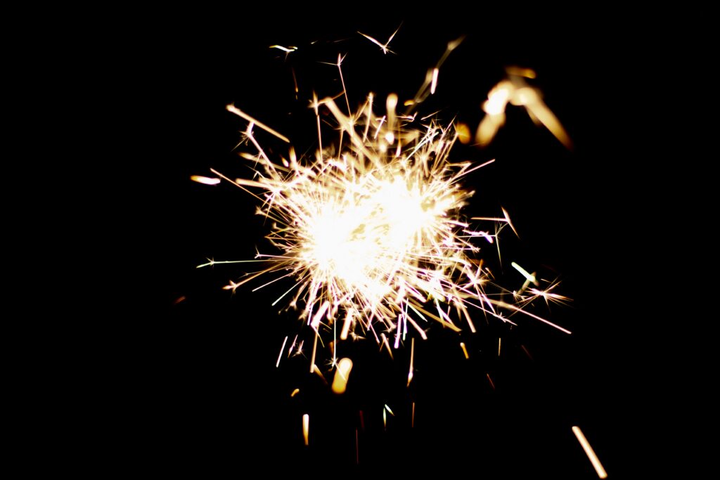 Captivating Sparkler Wallpaper: Bright Sparks on Dark Background