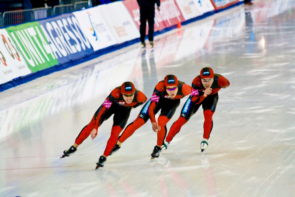 Dynamic Speed Skaters: Vibrant Wallpaper Showcasing Teamwork & Precision