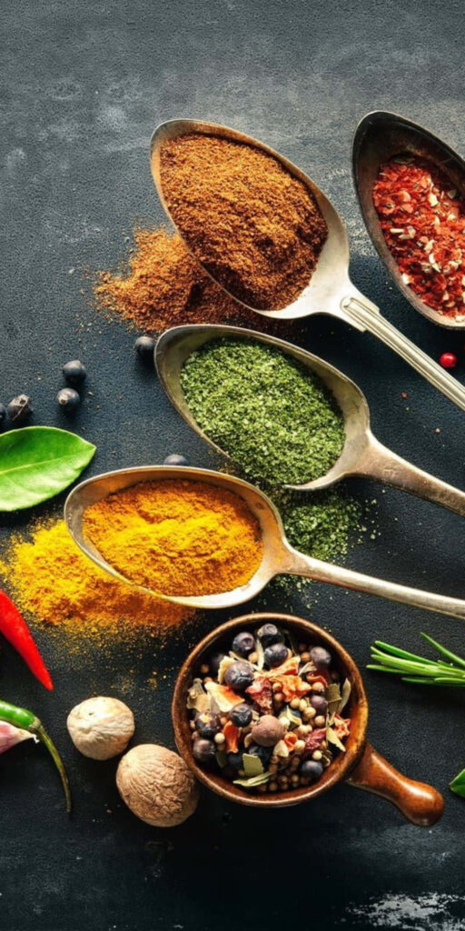 Vibrant Spice Arrangement on Spoons: Culinary Wallpaper Background