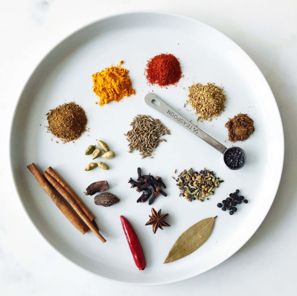 Vibrant Spice Assortment on White Plate - Striking Wallpaper Background
