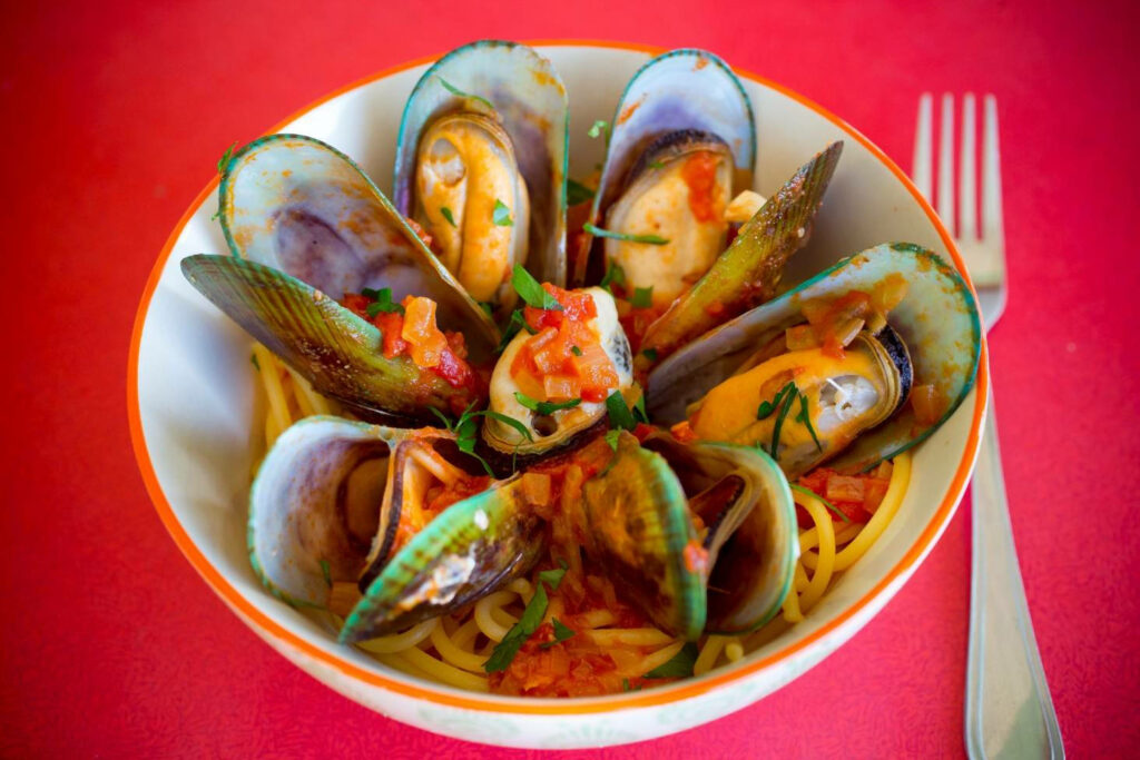 Vibrant Spicy Pasta & Mussels Wallpaper on Bright Red Background