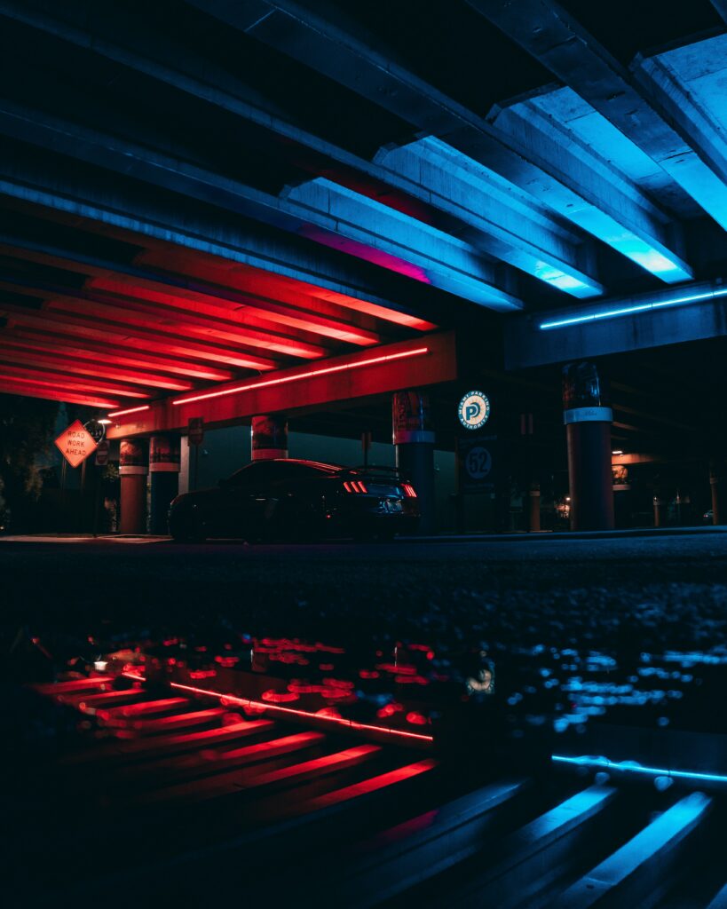 Futuristic Sports Car Wallpaper: Neon Lights & Reflections Under Overpass