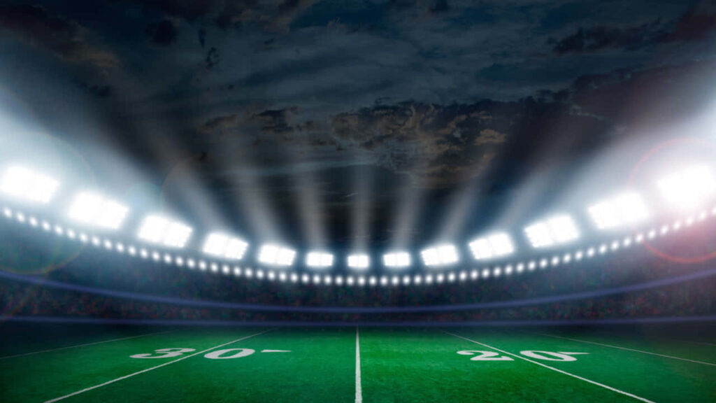 Vibrant Sports Wallpaper: Bright Stadium Under Dramatic Evening Sky