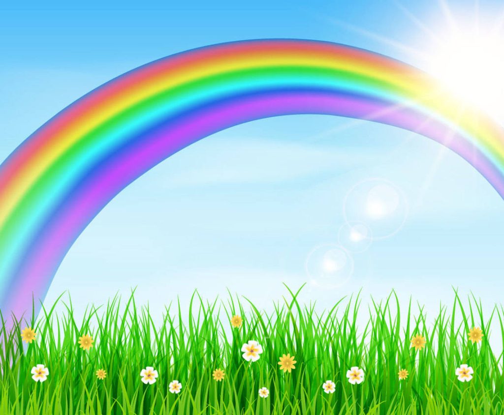 Vibrant spring wallpaper with rainbow arching over blue sky and flower-filled green meadow