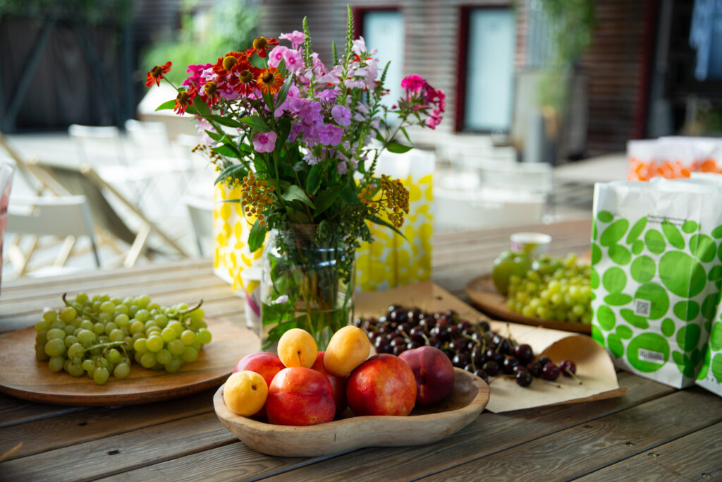 Vibrant Still Life Wallpaper: Flowers and Fruits on Wooden Table