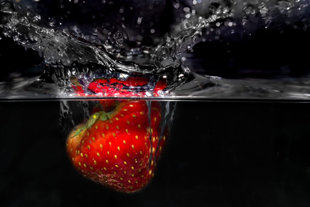 Vibrant Strawberry Splash Close-Up Wallpaper with Dark Background