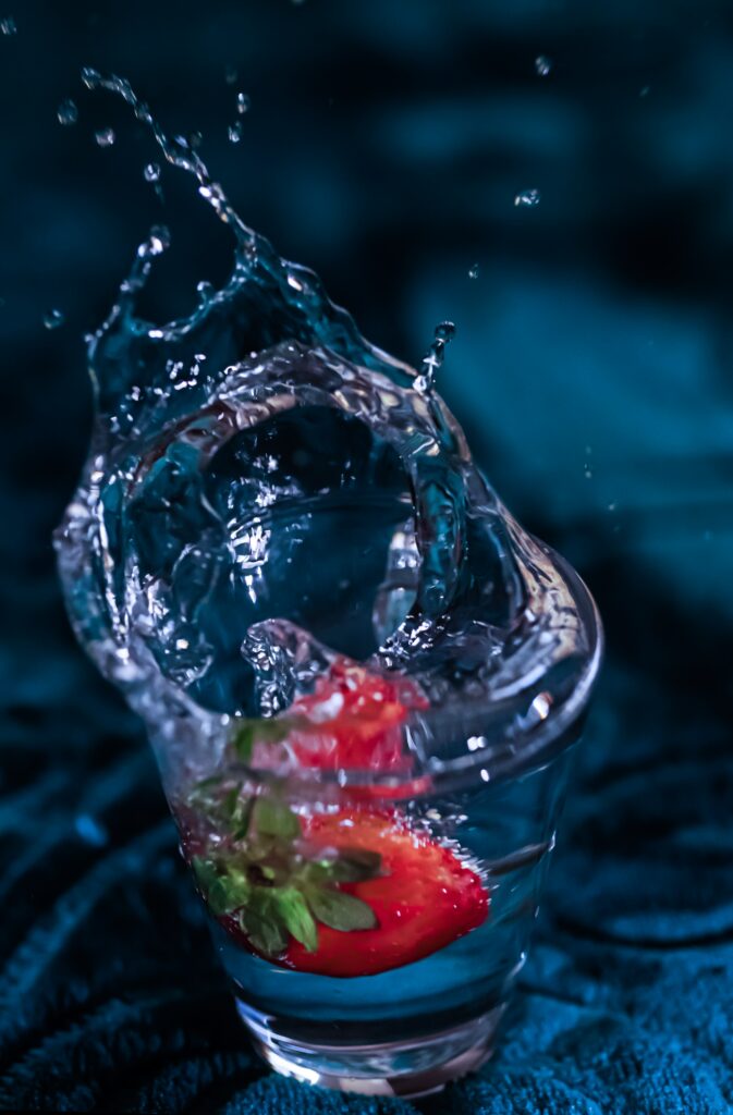 Vibrant Strawberry Splash Wallpaper Against Dark Background