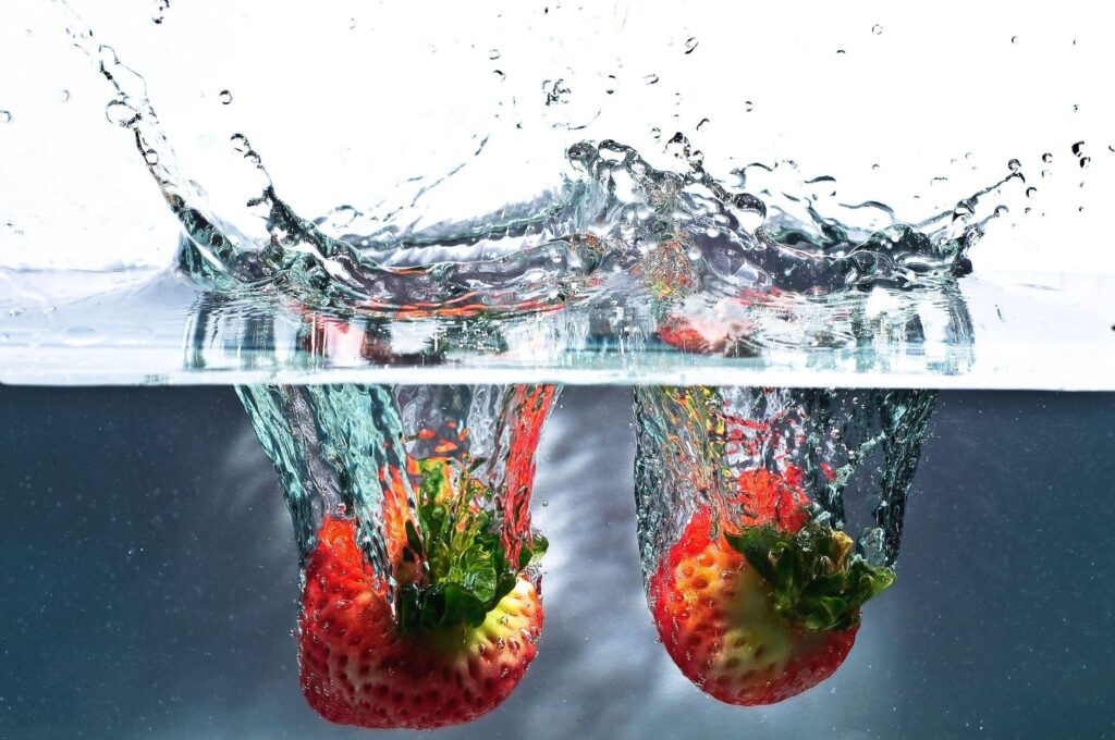 Vibrant Strawberry Splash Wallpaper: Refreshing Water and Ripples