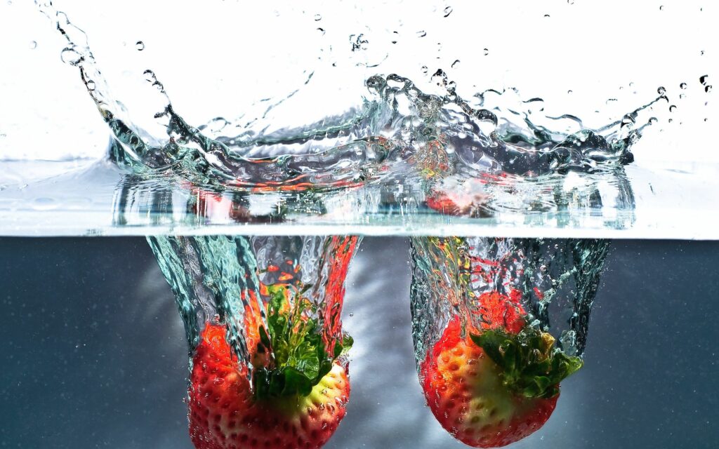 Vibrant Strawberry Splash Wallpaper: Refreshing Water Background