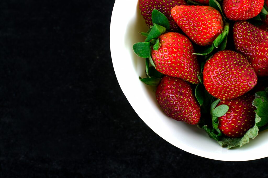 Vibrant Strawberry Wallpaper: Rich Red Hues on Dark Background