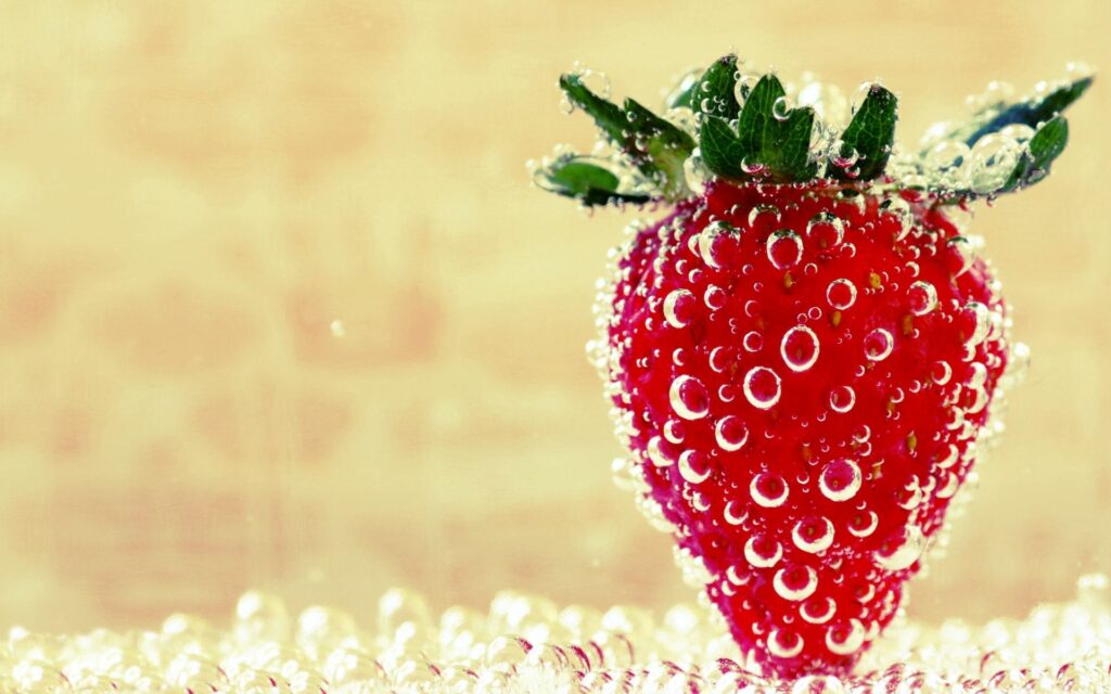 Vibrant Strawberry Wallpaper: Fresh & Sparkling Against Warm Background