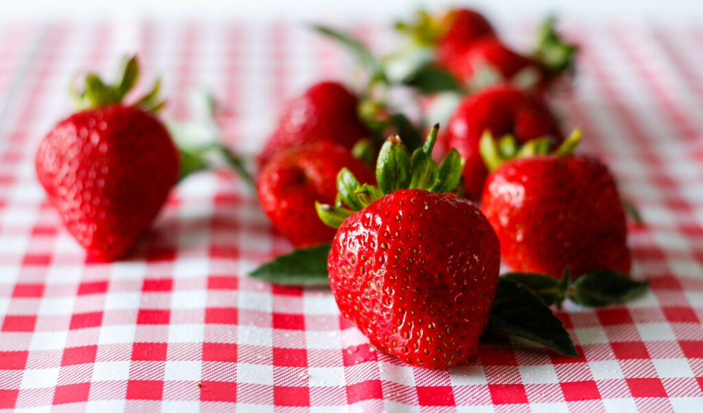 Vibrant Strawberry Wallpaper on Checkered Tablecloth - Fresh Appeal