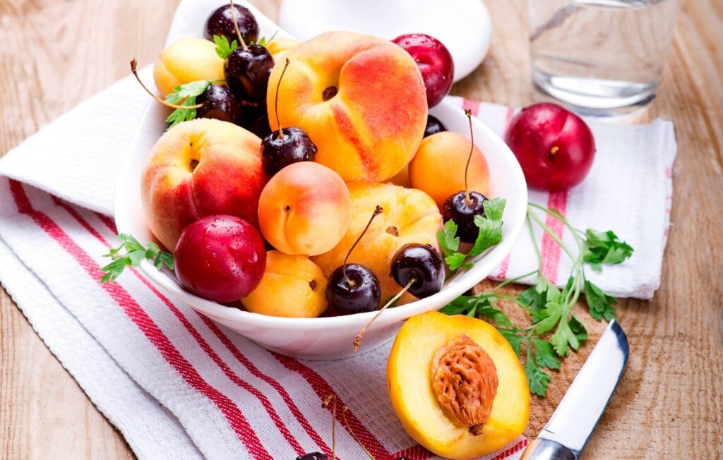 Summer's Bounty: Vibrant Fruit Bowl Wallpaper Background