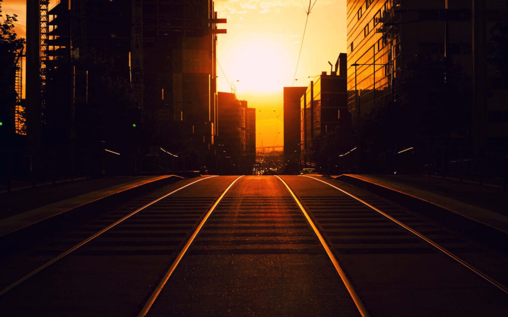 Vibrant Sunset Wallpaper: City Streets & Tram Tracks at Dusk