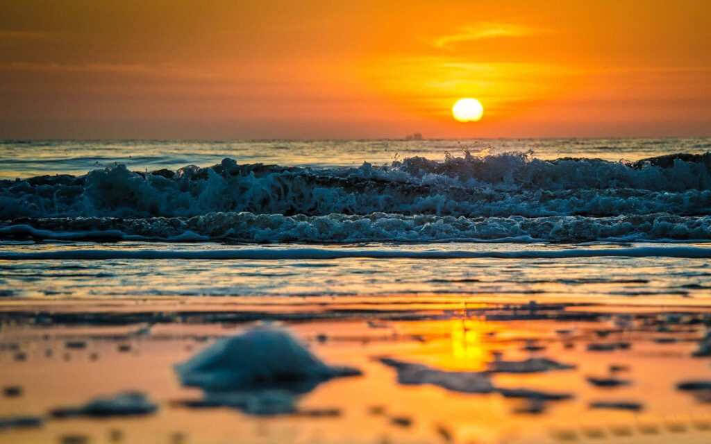 Vibrant Ocean Sunset Wallpaper: Sunset Over Waves Background