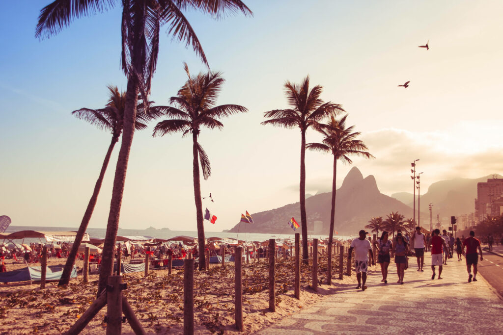 Vibrant Sunset over Rio Beach Promenade: Palm Trees & Ocean Waves Wallpaper