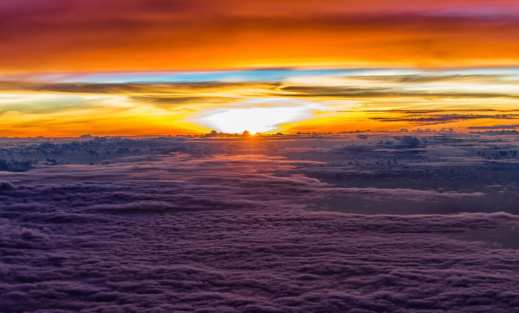 Vivid sunset over rolling clouds with vibrant orange yellow and purple hues serene sky wallpaper