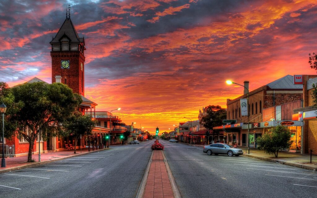 Vibrant Sunset Wallpaper Over Quiet Street with Charming Buildings